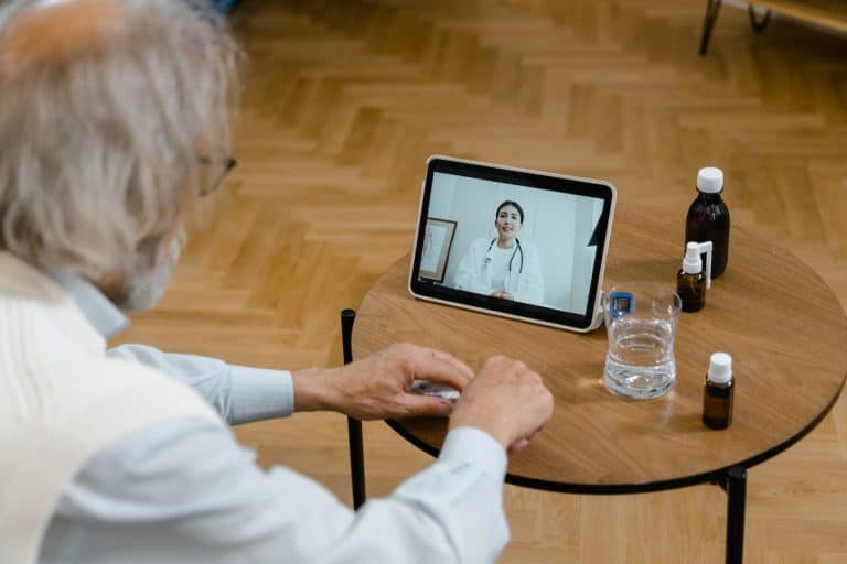 Personne en consultation virtuelle avec un psychologue sur un écran d'ordinateur