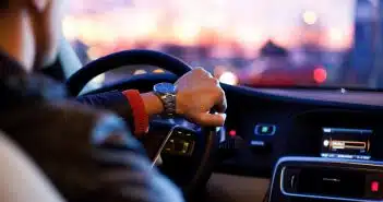man driving a car wearing wrist watch