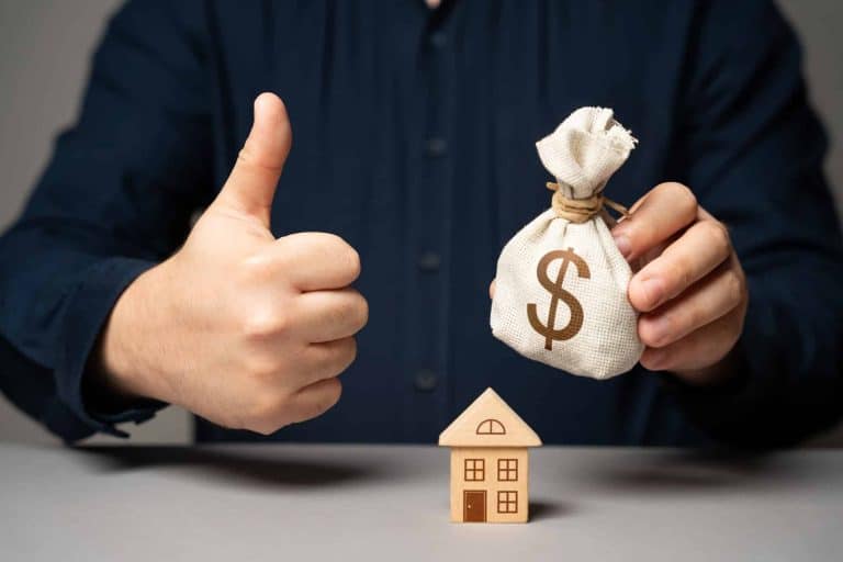 Personnes discutant d'un investissement immobilier avec documents et ordinateurs