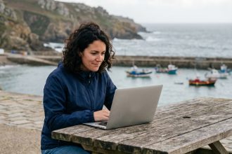 Femme en windbreaker travaillant au bord de la mer en Bretagne
