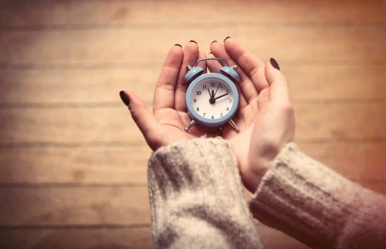 mains tenant une montre automatique avec un remontoir en arrière-plan